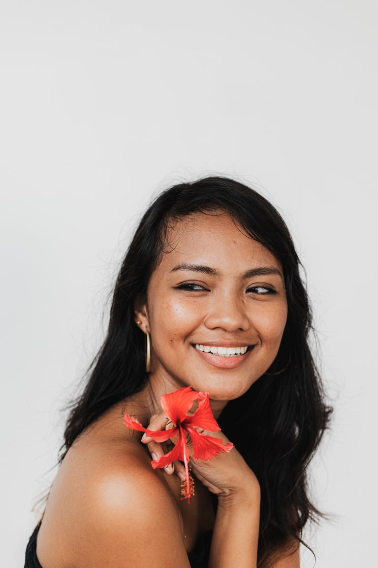 Portrait of a Smiling Woman Holding a Hibiscus Flower